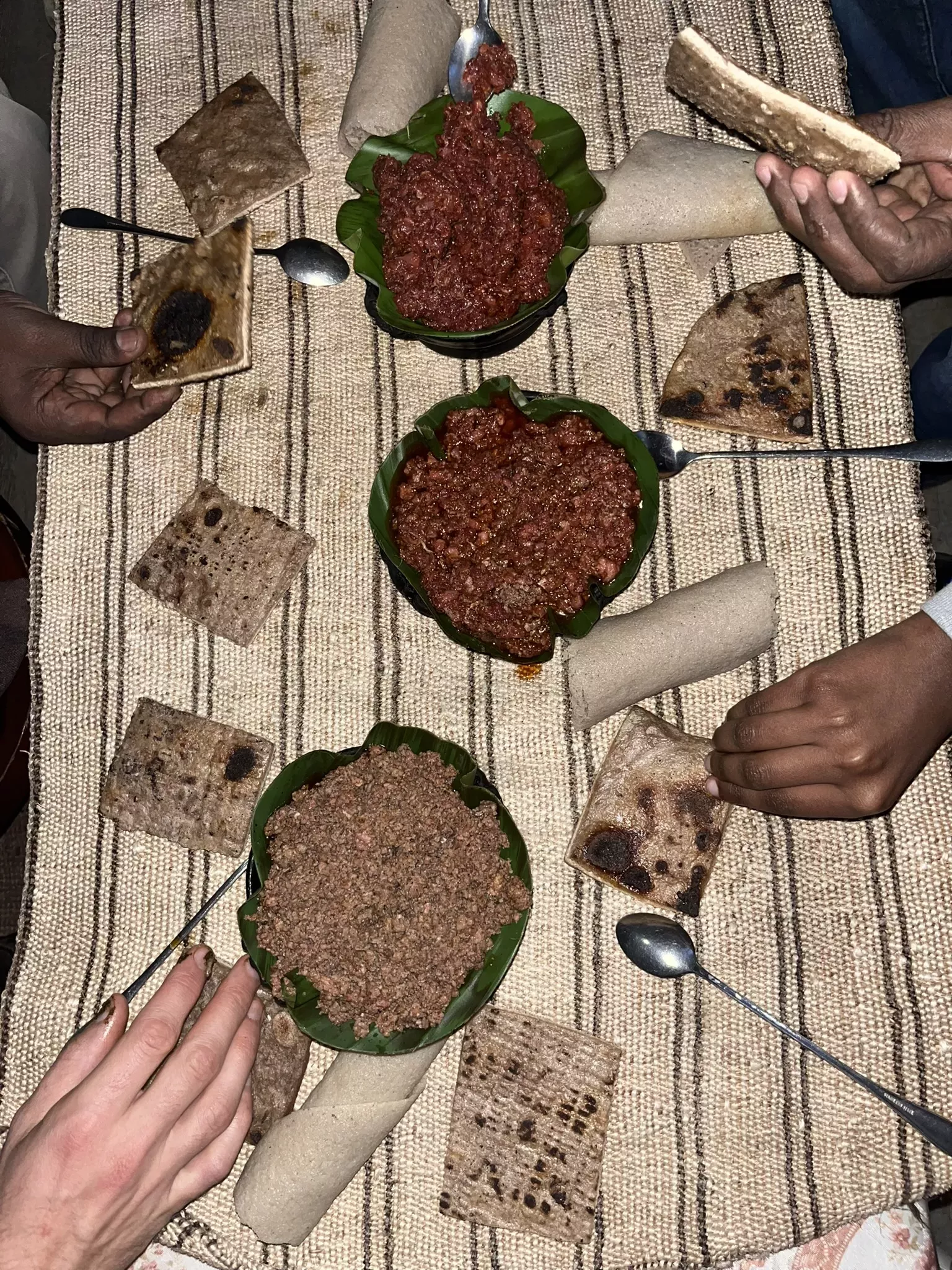 Kitfo - minced beef in a chilli powder sauce - is served alongside a enset-based flatbread © Sophie Jago, RBG Kew A table holds bowls of beef in sauce and flatbreads