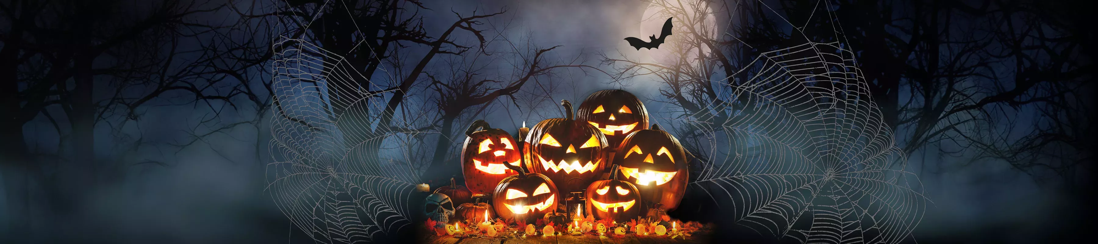 Halloween at Kew © RBG Kew A pile of glowing jack-o-lanterns against a dark misty background with cobwebs and bats
