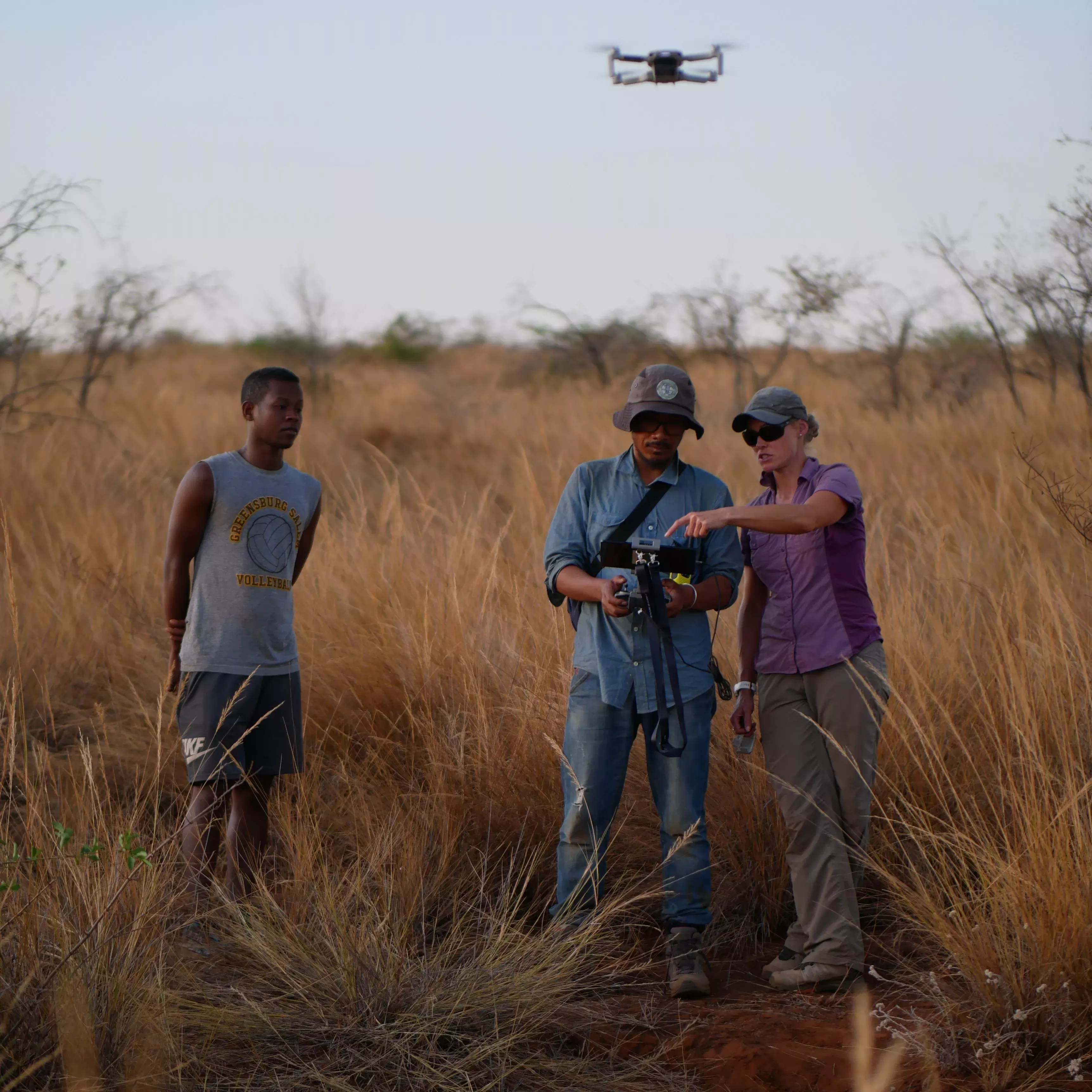 Drones are a powerful tool for surveying in modern conservation programmes © Stuart Cable, RBG Kew People stand in an area of grassland, one of them pilots a drone which hovers nearby