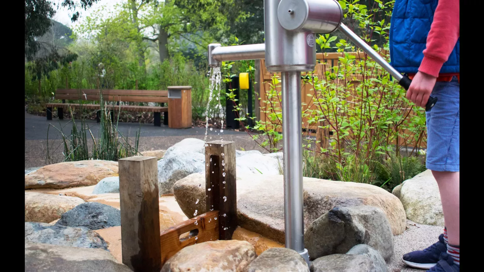 The Children's Garden A child pumps water in the the Children's Garden
